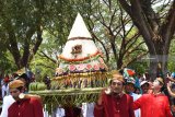 Sejumlah orang mengirab tumpeng dan sesaji sebelum dilarung di Waduk Bening Kabupaten, Madiun, Jawa Timur, Minggu (7/10). Warga setempat melarung tumpeng dan sesaji ke waduk tersebut guna melestarikan tradisi untuk mengungkapkan rasa syukur kepada Tuhan yang dilakukan setiap bulan Sura dalam penanggalan Jawa bersamaan bulan Muharram. Antara Jatim/Siswowidodo/mas/18.