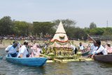 Sejumlah orang melarung tumpeng dan sesaji di Waduk Bening Kabupaten, Madiun, Jawa Timur, Minggu (7/10). Warga setempat melarung tumpeng dan sesaji ke waduk tersebut guna melestarikan tradisi untuk mengungkapkan rasa syukur kepada Tuhan yang dilakukan setiap bulan Sura dalam penanggalan Jawa bersamaan bulan Muharram. Antara Jatim/Siswowidodo/mas/18.