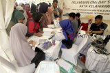 Warga antre membuat akte kelahiran di tenda Disdukcapil Kabupaten Bogor di kawasan Stadion Pakansari, Bogor, Jawa Barat, Jumat (12/10). Program 