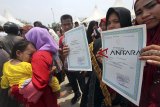 Warga antre membuat akte kelahiran di tenda Disdukcapil Kabupaten Bogor di kawasan Stadion Pakansari, Bogor, Jawa Barat, Jumat (12/10). Program 