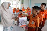 Murid Sekolah Dasar Islam Karakter (SDIK) Nurul Quran mengumpulkan dana untuk korban gempa dan tsunami di Palu dan Donggala melalui gerakan kemanusian di desa Lampeunerut, Kabupaten Aceh Besar, Aceh, Selasa (2/10). Gerakan penggalangan dana di seluruh sekolah di Aceh itu sebagai wujud kepedulian Aceh yang juga pernah terkena musibah gempa dan tsunami 26 Desember 2004 lalu untuk membantu masyarakat Palu dan Donggala. (Antara Aceh/Ampelsa/18)