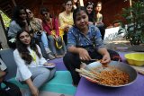 Mahasiswa asing asal Mumbai, India mengamati aktivitas warga saat berkunjung ke Kampung Ketandan, Surabaya, Jawa Timur, Kamis (11/10). Kunjungan ke kampung yang diikuti 98 dosen dan mahasiswa dari tujuh universitas di Asia tersebut guna menghasilkan ide desain arsitektural serta merasakan langsung tata ruang dan keunikan warga yang tinggal di sekitarnya. Antara Jatim/Moch Asim/18