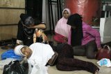 Sejumlah Pekerja Migran Indonesia (PMI) beristirahat saat tiba di Dinas Sosial Provinsi Kalbar, Rabu (17/10/2018) malam. Berdasarkan pemeriksaan BP3TKI melalui P4TKI Entikong tercatat 95 PMI asal Jawa Timur, Aceh, Pulau Sumatra dan Kalbar dipulangkan Malaysia karena tidak memiliki ijin kerja dan paspor serta lari dari majikannya. ANTARA FOTO/Reza Novriandi/jhw