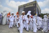 Siswa TK didampingi gurunya mengikuti peragaan manasik haji yang diselenggarakan oleh Ikatan Guru Taman Kanak-kanak Indonesia (IGTKI) di Lapangan Dadaha Kota Tasikmalaya, Jawa Barat, Rabu (3/10). Kegiatan yang diikuti 3.000 siswa TK se-Kota Tasikmalaya bertujuan untuk menanamkan akidah dan pengenalkan tata cara ibadah haji sejak dini yang wajib dilaksanakan oleh setip muslim yang mampu menjalankannya. ANTARA JABAR/Adeng Bustomi/agr/18.