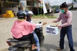 Seorang warga perbatasan Indonesia-Malaysia menggalang donasi dari pengendara di Balai Karangan, Kecamatan Sekayam, Kabupaten Sanggau, Kalbar, Minggu (30/9). Aksi penggalangan dana yang dilakukan bersama Komunitas Budaya Sekayam (KBS), Persatuan Orang Melayu (POM), Palang Merah Remaja (PMR), Medis Nusantara Sehat dan Paguyuban Tri Wulan tersebut, nantinya akan disalurkan untuk korban gempa tsunami di Palu, Donggala dan Mamuju di Sulawesi Tengah. ANTARA FOTO/Agus Alfian/jhw/18