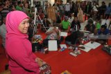 Gubernur Jawa Timur terpilih, Khofifah Indar Parawansa (kanan) berpose untuk dijadikan model lukisan di sela-sela gelaran Pasar Seni Lukis Indonesia (PSLI) 2018 di JX Internasional Surabaya, Jawa Timur, Kamis (18/10/2018). Sebanyak 50 pelukis yang merupakan peserta dari PSLI 2018 tersebut ikut serta dalam melukis bersama. Antara Jatim/M Risyal Hidayat/mas.