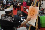 Sejumlah pelukis menyelesaikan lukisan dengan model Gubernur Jawa Timur terpilih, Khofifah Indar Parawansa di sela-sela gelaran Pasar Seni Lukis Indonesia (PSLI) 2018 di JX Internasional Surabaya, Jawa Timur, Kamis (18/10/2018). Sebanyak 50 pelukis yang merupakan peserta dari PSLI 2018 tersebut ikut serta dalam melukis bersama. Antara Jatim/M Risyal Hidayat/mas.