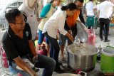 Menteri Badan Usaha Milik Negara (BUMN) Rini Soemarno (tengah) memasak nasi saat berkunjung di dapur umum posko pengungsian di halaman Kantor PLN Palu, Sulawesi Tengah, Rabu (3/10/2018). Kunjungan tersebut untuk memantau ketersediaan BBM, Listrik dan beberapa posko pengungsian korban gempa bumi Palu dan Donggala yang didirikan oleh sejumlah BUMN seperti Pertamina, PLN dan Telkom. ANTARA FOTO/Abriawan Abhe/hp.