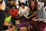 Menteri Badan Usaha Milik Negara (BUMN) Rini Soemarno (tengah) mengupas bawang saat berkunjung di dapur umum posko pengungsian di halaman Kantor PLN Palu, Sulawesi Tengah, Rabu (3/10/2018). Kunjungan tersebut untuk memantau ketersediaan BBM, Listrik dan beberapa posko pengungsian korban gempa bumi Palu dan Donggala yang didirikan oleh sejumlah BUMN seperti Pertamina, PLN dan Telkom. ANTARA FOTO/Abriawan Abhe/hp. 