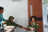 Seorang murid Taman Kanak-Kanak Kartika menggalang donasi untuk bencana alam Sulawesi Tengah di daerah perbatasan di Balai Karangan, Kecamatan Sekayam, Kabupaten Sanggau, Kalbar, Kamis (4/10). Hasil dari aksi yang dilakukan untuk menumbuhkan rasa peduli bagi sesama tersebut, selanjutnya akan disalurkan bagi korban gempa tsunami di Sulteng. ANTARA FOTO/Agus Alfian/jhw/18