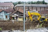 Pekerja meratakan tanah dengan alat berat di area proyek pembangunan jalur kereta api rel ganda Bogor-Sukabumi, Cicurug, Kabupaten Sukabumi, Jawa Barat, Senin (22/10/2018). Pemerintah pusat menyiapkan dana sebesar Rp2,45 triliun untuk pembangunan jalur kereta api tersebut sepanjang 57 km yang ditargetkan rampung pada tahun 2020. ANTARA JABAR/Nurul Ramadhan/agr.