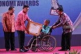 Menteri Dalam Negeri Tjahjo Kumolo (kedua kiri) didampingi Gubernur Jawa Timur Soekarwo (kiri) menyerahkan penghargaan salah satu tim juri Bayu Perdana (kedua kanan) saat Penganugerahaan Otonomi Awards dan Kompetisi Inovasi Pelayanan Publik (Kovablik) 2018 di Surabaya, Jawa Timur, Senin (22/10/2018). Kegiatan tersebut merupakan ajang untuk mengapresiasi instansi pemerintah maupun swasta dalam menciptakan inovasi pelayanan publik dan membuka akses bagi kaum difabel dan kelompok rentan. Antara Jatim/Moch Asim/ZK.