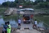 Warga menyebrang sungai Citarum menggunakan perahu eret di Kawasan Rengasdengklok, Karawang, Jawa Barat, Jumat (05/10). Perahu eret tersebut digunakan warga setempat untuk menyeberang antar desa Sumbersari dan Desa Renggasdengklok Selatan, Wilayah Karawang - Bekasi dengan ongkos untuk motor Rp2.000 dan Mobil Rp10.000 per sekali menyeberang. ANTARA JABAR/M Ibnu Chazar/agr/18.