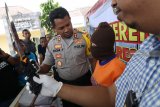 Kapolres Kediri AKBP Roni Faisal (kiri) berbincang dengan tersangka percobaan pembunuhan berinisial RS saat rilis di Mapolres Kediri, Jawa Timur, Selasa (2/10). Kasus penganiayaan berat yang dilakukan karyawan lembaga pembiayaan terhadap atasannya itu berlatar belakang utang piutang. Antara Jatim/Prasetia Fauzani/mas/18.