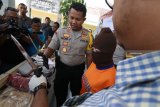 Kapolres Kediri AKBP Roni Faisal (kiri) berbincang dengan tersangka percobaan pembunuhan berinisial RS saat rilis di Mapolres Kediri, Jawa Timur, Selasa (2/10). Kasus penganiayaan berat yang dilakukan karyawan lembaga pembiayaan terhadap atasannya itu berlatar belakang utang piutang. Antara Jatim/Prasetia Fauzani/mas/18.