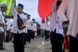 Santri membentangkan bendera merah putih saat Kirab Santri dan Jalan Sehat Sahabat Santri di alun-alun Sidoarjo, Jawa Timur, Minggu (28/10/2018). Acara yang dihadiri ribuan santri ini mengambil tema  '1 Juta Kirab Santri'. Antara Jatim/Umarul Faruq/ZK