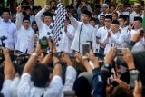 Presiden Joko Widodo (keempat kanan) didampingi Mustasyar PBNU sekaligus calon Wakil Presiden nomor urut 01 Ma'ruf Amin (kedua kanan), Kepala Kantor Staf Presiden Moeldoko (ketiga kanan), Menteri Tenaga Kerja Hanif Dhakiri (kanan), Menteri Pertanian Amran Sulaiman (kiri), Gubernur Jawa Timur Soekarwo (keempat kiri) dan Ketua Umum Partai Kebangkitan Bangsa (PKB) Muhaimin Iskandar (kedua kiri) serta Bupati Sidoarjo Saiful Ilah (ketiga kiri) melepas Kirab Santri dan Jalan Sehat Sahabat Santri di alun-alun Sidoarjo, Jawa Timur, Minggu (28/10/2018). Acara yang dihadiri ribuan santri ini mengambil tema '1 Juta Kirab Santri'. Antara Jatim/Umarul Faruq/ZK