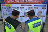 Anggota kepolisian melihat papan skema pengaturan lalu lintas peringatan hari Hari Santri Nasional (HSN) di Gelora Delta Sidoarjo, Jawa Timur, Kamis (25/10/2018). Polda Jawa Timur mempersiapkan pengamanan 1800 personil Polisi untuk acara tersebut. Antara Jatim/Umarul Faruq/ZK