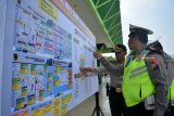 Anggota kepolisian melihat papan skema pengaturan lalu lintas peringatan hari Hari Santri Nasional (HSN) di Gelora Delta Sidoarjo, Jawa Timur, Kamis (25/10/2018). Polda Jawa Timur mempersiapkan pengamanan 1800 personil Polisi untuk acara tersebut. Antara Jatim/Umarul Faruq/ZK