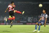 Pesepakbola Madura United, Benny Wahyudi (kiri) menghalau bola dari pesepakbola Arema FC , Johan Al Farisy (kanan) dalam pertandingan amal di Stadion Kanjuruhan, Malang, Jawa Timur, Sabtu (29/9). Pertandingan tersebut diadakan untuk mengumpulkan bantuan bagi korban gempa Palu-Donggala serta keluarga suporter Persija Haringga Sirilla. Antara Jatim/Ari Bowo Sucipto/mas/18.