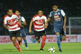 Pesepakbola Arema FC , Bagas Adi Nugroho (kanan) berusaha melepaskan diri dari hadangan dua pesepakbola Madura United dalam pertandingan amal di Stadion Kanjuruhan, Malang, Jawa Timur, Sabtu (29/9). Pertandingan tersebut diadakan untuk mengumpulkan bantuan bagi korban gempa Palu-Donggala serta keluarga suporter Persija Haringga Sirilla. Antara Jatim/Ari Bowo Sucipto/mas/18.