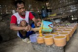 Petani menyelesaikan pembuatan gula merah dari bunga pohon kelapa di desa Ciracap, Sukabumi, Jawa Barat, Minggu (7/10). Setiap hari petani tersebut mampu menyadap 100 pohon kelapa untuk mendapatkan 30 kg gula merah dengan harga jual Rp10 ribu per kilogram. ANTARA JABAR/Nurul Ramadhan/agr/18.