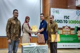 Isra Ruddin - Direktur Utama IRcomm Norton Capital sedang menyaksikan Eti Suyanti - Kepala Sekolah SMKN 57 Jakarta Selatan bertukaran surat kerjasama terkait dengan pemberikan DROPBOX tempat sampah terpilah khusus kemasan karton minuman oleh Reza Andreanto - Environment Manager Tetra Pak Indonesia yang disaksikan pula oleh Rizal Bukhari - Senior Engagement Manager FSC Indonesia di SMKN 57 Jakarta Selatan. (Megapolitan.Antaranews.Com/Foto/Humas FSC Indonesia).