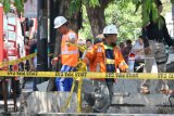 Petugas PGN memasang garis pemberitahuan di lokasi pipa gas yang terbakar di Jalan Ngagel Jaya Selatan, Surabaya, Jawa Timur, Jumat (26/10/2018). Sekitar empat kendaraan pemadam kebakaran dikerahkan untuk memadamkan semburan api dari pipa gas yang diduga pecah setelah terkena alat berat (back hoe) saat pengerukan endapan sungai itu. Antara Jatim/Didik Suhartono/ZK.