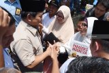 Calon Presiden nomor urut 02 Prabowo Subianto (kiri) menyapa pendukungnya di sela-sela kegiatan berziarah di makam Gubernur Soerjo di Magetan, Jawa Timur, Rabu (31/10/2018). Prabowo melakukan serangkaian kegiatan di Magetan, antara lain melakukan ziarah ke makam Gubernur Soerjo yang merupakan gubernur pertama Jawa Timur. Antara Jatim/Siswowidodo/ZK