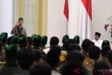 Presiden Joko Widodo (kanan) menyimak sambutan Ketua Umum Pengurus Besar Himpunan Mahasiswa Islam (PB HMI) R Saddam Al Jihad saat menghadiri Sekolah Pimpinan Himpunan Mahasiwa Islam (Sepim HMI) Tahun 2018 di Istana Bogor, Jawa Barat, Jumat (5/10/2018). ANTARA FOTO/Wahyu Putro A/kye