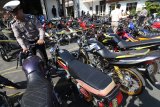 Petugas melakukan pengecekan barang bukti sepeda motor balap liar di Polresta Kediri, Jawa Timur, Senin (8/10). Polisi berhasil mengamankan sebanyak 116 unit sepeda motor dan memberikan 155 lebar surat tilang saat razia balap liar yang dilakukan selama dua hari guna merespon pengaduan masyarakat. Antara Jatim/Prasetia Fauzani/mas/18.