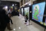 Pengunjung mengamati lukisan karya pelajar pada pameran seni rupa bertajuk 'Mencari Jejak' di Kota Kediri, Jawa Timur, Minggu (14/10). Pameran yang diselenggarakan yayasan Omah Panji dengan menampilkan 59 karya tersebut bertujuan meregenerasi perupa muda daerah. Antara Jatim/Prasetia Fauzani/mas/18