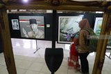 Pengunjung mengamati lukisan karya pelajar pada pameran seni rupa bertajuk 'Mencari Jejak' di Kota Kediri, Jawa Timur, Minggu (14/10). Pameran yang diselenggarakan yayasan Omah Panji dengan menampilkan 59 karya tersebut bertujuan meregenerasi perupa muda daerah. Antara Jatim/Prasetia Fauzani/mas/18