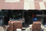 Pekerja membangun lapak semi permanen di belakang gedung pasar Setono Betek Kota Kediri, Jawa Timur, Selasa (16/10/2018). Gedung pasar tradisional seluas 40x80 meter senilai Rp25 miliar yang direvitalisasi pada tahun 2017 itu dibangun lapak tambahan semi permanen guna menampung 40 pedagang daging 38 pedagang ayam dan 10 pedagang buah yang tidak mendapatkan lapak di gedung utama. Antara Jatim/Prasetia Fauzani/mas.