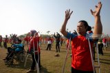 Penyandang Tuna Daksa mengikuti senam goyang dayung di Lapangan Tawangsari Blitar, Jawa Timur, Sabtu (29/9). Senam massal bersama penyandang Disabilitas yang tergabung dalam Paguyuban Penyandang Disabilitas Indonesia (PPDI) tersebut guna mendukung dan menyemarakkan pagelaran Asian Para Games 2018 . Antara Jatim/Irfan Anshori/mas/18.