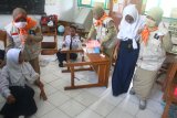 Guru memberikan pertolongan pada siswa berkebutuhan khusus yang menjadi korban dalam Simulasi Penanganan bencana Gempa Bumi di Sekolah Menengah Pertama - Luar Biasa (SMPLB) Negeri, Malang, Jawa Timur, Senin (15/10). Simulasi tersebut diadakan untuk melatih kesiapan para siswa berkebutuhan khusus dan guru dalam menghadapi bencana gempa bumi. Antara Jatim/Ari Bowo Sucipto/mas/18.