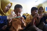 Komunitas Generasi Baru Indonesia (GenBI) Jember melakukan sosialisasi ciri keaslian uang rupiah di SLB-A Bintoro, Patrang, Jember, Jawa Timur, Sabtu (20/10/2018). GenBI Jember mengajar anak-anak tuna netra di sekolah itu bermaterikan pengenalan keaslian uang rupiah melalui tanda kode tuna netra (blind-code) dan ciri fisik uang. Antara Jatim/Seno/ZK.