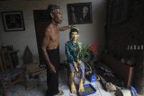 Pemangku adat menyiapkan patung tokoh Nyi Wandan yang dianggap sebagai leluhur desa setempat saat tradisi Ngunjung Buyut Gading di desa Gadingan, Indramayu, Jawa Barat, Rabu (24/10/18). Tradisi Ngunjung Buyut Gading yang merupakan tradisi masyarakat setempat untuk mengunjungi makam leluhur usai masa panen. ANTARA JABAR/Dedhez Anggara/agr.