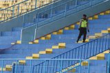 Petugas keamanan melintas di tribun penonton yang kosong saat pertandingan Liga 1 GOJEK antara Arema FC melawan Bali United di Stadion Kanjuruhan, Malang, Jawa Timur, Sabtu (20/10/2018). Komisi Disiplin (Komdis) PSSI menjatuhi sanksi untuk Arema FC yakni menggelar pertandingan tanpa penonton hingga akhir musim kompetisi Liga I GOJEK pasca rusuh suporter saat pertandingan Arema melawan Persebaya pada tanggal 6 Oktober 2018 lalu. Antara Jatim/Ari Bowo Sucipto/ZK.