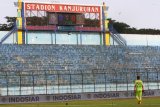 Penjaga gawang Bali United, I Made Wardana melintas di depan tribun penonton yang kosong saat pertandingan Liga 1 GOJEK antara Arema FC melawan Bali United di Stadion Kanjuruhan, Malang, Jawa Timur, Sabtu (20/10/2018). Komisi Disiplin (Komdis) PSSI menjatuhi sanksi untuk Arema FC yakni menggelar pertandingan tanpa penonton hingga akhir musim kompetisi Liga I GOJEK pasca rusuh suporter saat pertandingan Arema melawan Persebaya pada tanggal 6 Oktober 2018 lalu. Antara Jatim/Ari Bowo Sucipto/ZK. 