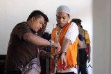 Polisi memborgol terdakwa, Ridwan , kasus pembunuhan sekeluarga seusai mengikuti sidang putusan di Pengadilan Negeri, Banda Aceh, Rabu (24/10). Hakim menjatuhi vonis hukuman mati terhadap terdakwa Ridwan, karena terbukti bersalah melakukan pembunuhan berencana terhadap sekeluarga, Tjie Sun alias Asun (suami), Minarni (istri), dan seorang anak Callietos NG pada Januari 2018. (Antara Aceh/Ampelsa/18)
