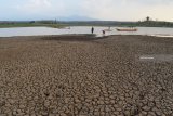 Sejumlah warga berada di dekat pintu air Waduk Dawuhan di Desa Plumpungrejo, Kabupaten Madiun, Jawa Timur, Rabu (3/10). Waduk yang memiliki daerah irigasi seluas 2.823 hekare tersebut airnya menyusut drastis hingga sebagian besar dasar waduk mengering. Antara Jatim/Siswowidodo/mas/18