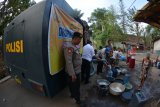 Warga mengantre untuk mendapatkan air bersih yang dibagikan Polres Situbondo di Desa Selowogo, Bungatan, Situbondo, Jawa Timur, Senin (1/10). Polres Situbondo menyalurkan bantuan air bersih untuk membantu warga masyarakat yang dilanda kekeringan. Antara Jatim/Seno/mas/18.