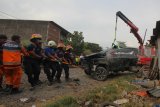 Petugas mengevakuasi mobil yang tertabrak kereta api (KA) di perlintasan KA Jalan Pagesangan, Surabaya, Jawa Timur, Minggu (21/10/2018). Mobil Pajero dengan nomor polisi W 1165 YV itu tertabrak KA Sri Tanjung saat melintasi perlintasan KA Jalan Pagesangan dan mengakibatkan tiga orang satu keluarga berinisial G S P (54), I W (45) dan seorang anak kecil tewas dalam mobil itu. Antara Jatim/Didik Suhartono/ZK