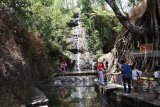 Pengunjung menikmati wisata air terjun Roro Kuning, Desa Bajulan, Nganjuk, Jawa Timur, Minggu (21/10/2018). Air terjun setinggi 15 meter di lereng gunung Wilis tesebut pada hari libur tetap ramai dikunjungi wisatawan meskipun debit air berkurang akibat musim kemarau. Antara Jatim/Prasetia Fauzani/ZK