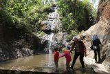 Pengunjung menikmati wisata air terjun Roro Kuning, Desa Bajulan, Nganjuk, Jawa Timur, Minggu (21/10/2018). Air terjun setinggi 15 meter di lereng gunung Wilis tesebut pada hari libur tetap ramai dikunjungi wisatawan meskipun debit air berkurang akibat musim kemarau. Antara Jatim/Prasetia Fauzani/ZK