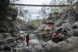 Pengunjung berfoto di kawasan wisata alam Leuwi Kenit, Geopark Ciletuh, Kabupaten Sukabumi, Jawa Barat, Minggu (14/10). Leuwi Kenit yang menawarkan konsep wahana bermain river tubbing, flying fox dan panjat tebing dengan suasana keindahan alam tersebut menjadi alternatif wisata liburan di akhir pekan bersama keluarga. ANTARA JABAR/Nurul Ramadhan/agr/18.