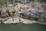 Pengunjung berfoto di kawasan wisata alam Leuwi Kenit, Geopark Ciletuh, Kabupaten Sukabumi, Jawa Barat, Minggu (14/10). Leuwi Kenit yang menawarkan konsep wahana bermain river tubbing, flying fox dan panjat tebing dengan suasana keindahan alam tersebut menjadi alternatif wisata liburan di akhir pekan bersama keluarga. ANTARA JABAR/Nurul Ramadhan/agr/18.