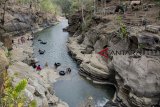 Pengunjung berfoto di kawasan wisata alam Leuwi Kenit, Geopark Ciletuh, Kabupaten Sukabumi, Jawa Barat, Minggu (14/10). Leuwi Kenit yang menawarkan konsep wahana bermain river tubbing, flying fox dan panjat tebing dengan suasana keindahan alam tersebut menjadi alternatif wisata liburan di akhir pekan bersama keluarga. ANTARA JABAR/Nurul Ramadhan/agr/18.