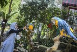 Pengunjung memberi pakan untuk burung makaw biru kuning (Ara arauna) saat berwisata di Wisata Taman Burung Bird & Bromelia Pavilion, Bandung, Jawa Barat, Sabtu (20/10/2018). Bird & Bromelia Pavilion yang memiliki 300 jenis burung dari berbagai wilayah di Indonesia tersebut merupakan wisata edukasi baru untuk mengenalkan jenis burung pada keluarga yang akan berlibur di kota Bandung. ANTARA JABAR/Raisan Al Farisi/agr.